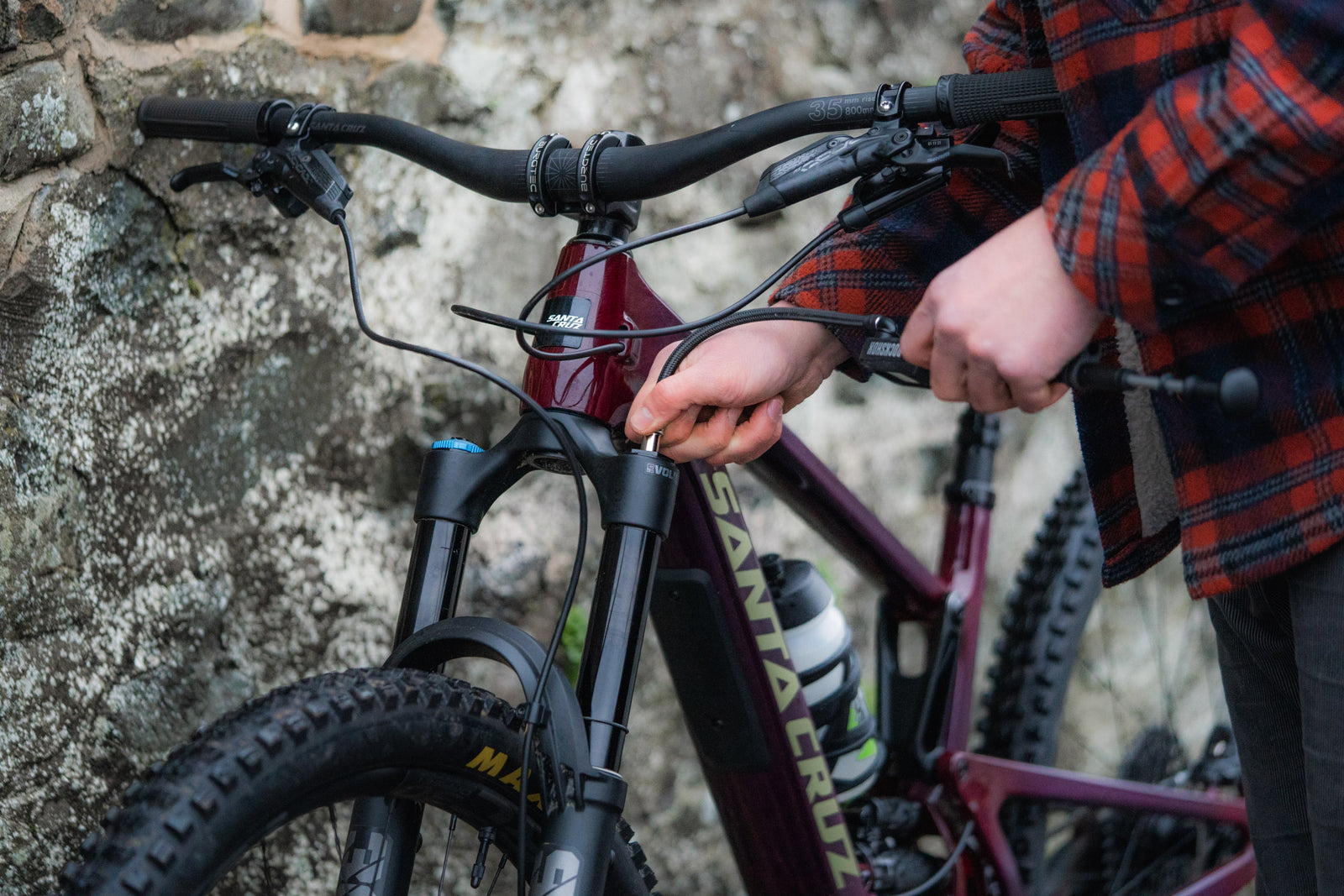 Tomy screwing a shock pump onto the fork of a Santa Cruz Hightower 